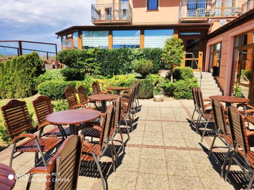 a patio with tables and chairs in front of a building at Panorama_SPA in Trzęsacz