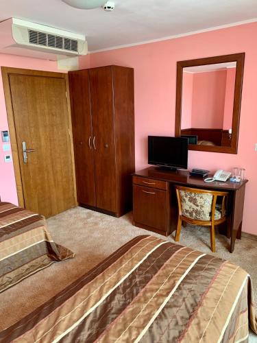 a bedroom with a bed and a desk with a computer at Hotel Elena in Veliko Tŭrnovo