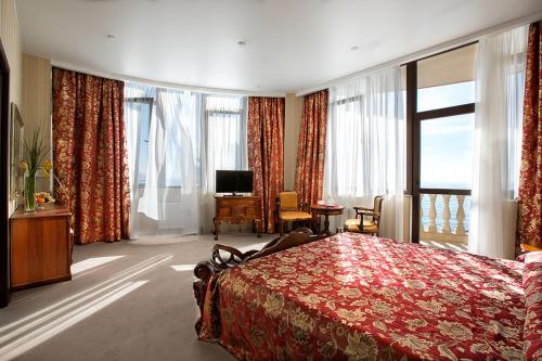 um quarto de hotel com uma cama e uma grande janela em Dolphin Resort by Stellar Hotels, Sochi em Sochi