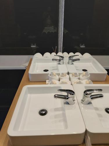 three white sinks sitting on a counter in a bathroom at Douro Cister Hotel Resort in Ucanha