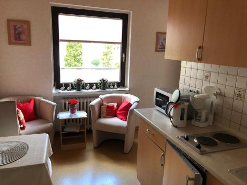a small kitchen with two chairs and a window at Pension Fischer in Bad Driburg