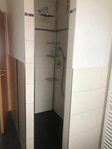 a shower in a bathroom with white tiles at Ferienwohnung Winkler in Rothenburg ob der Tauber