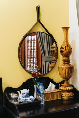 a mirror on top of a dresser in a room at Hue 1962 INN in Hue