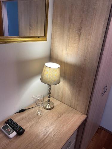 a lamp sitting on a table with a remote control at Hotel Martini Zagreb Hotel and Restaurant in Sesvete