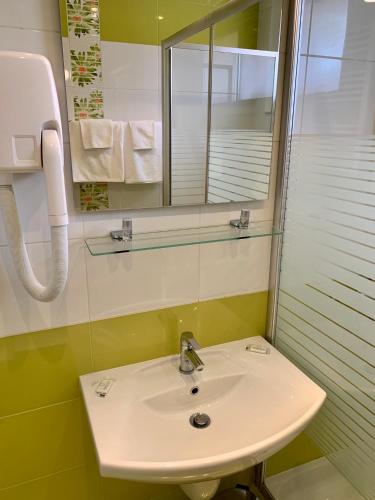 a bathroom with a sink and a mirror at Hotel Elena in Veliko Tŭrnovo