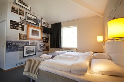 a bedroom with two beds and pictures on the wall at Lisebergsbyns B&B in Gothenburg