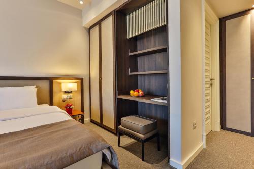 a hotel room with a bed and a chair at Hotel Bono in Budva