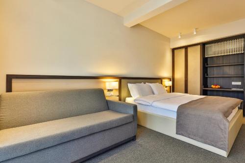 a bedroom with a bed and a couch at Hotel Bono in Budva