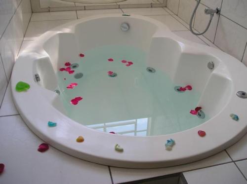 a bath tub with flowers on it in a bathroom at Hotel Urubupunga in Ilha Solteira