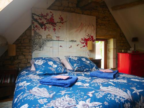 Una cama con mantas azules y almohadas. en Au Coeur de la Cour, en Saint-Georges-sur-Cher
