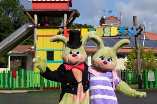 two stuffed rabbits standing in front of a playground at Lisebergsbyns B&B in Gothenburg