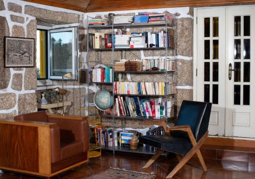 un salon avec une étagère et des livres dans l'établissement Quinta do Mirante, à Castelo de Paiva