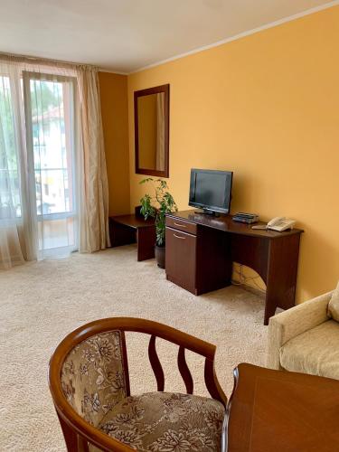a living room with a desk and a television at Hotel Elena in Veliko Tŭrnovo