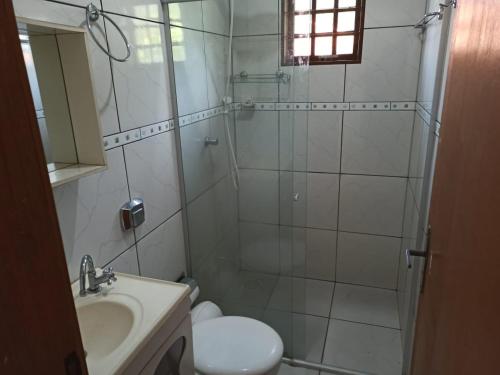 ein Badezimmer mit Dusche, Toilette und Waschbecken in der Unterkunft Sítio Recanto da Paz - Chácara para temporada com piscina aquecida in Hidrolândia