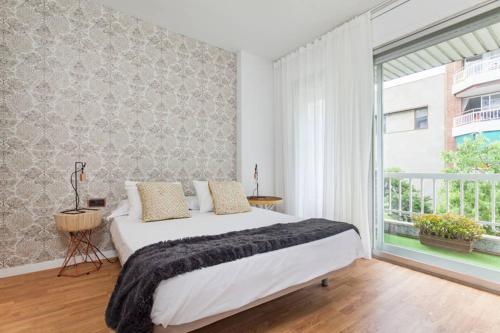 a bedroom with a large bed and a large window at Art House Renoir Plaza Universitat Sant Antoni in Barcelona