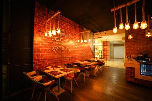 a restaurant with tables and chairs against a brick wall at Star Emirates Downtown Hotel Salalah in Salalah