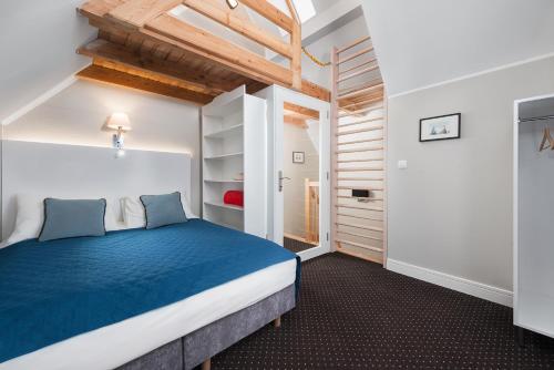 1 dormitorio con 1 cama azul en una habitación en Domki Hallerowka Resort, en Władysławowo
