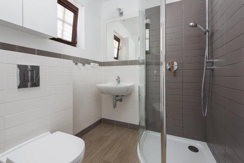 une salle de bain avec toilettes, lavabo et douche dans l'établissement Domki Hallerowka Resort, à Władysławowo