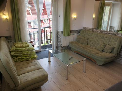 a living room with a couch and a glass table at Apartamenty u Łukasza in Zakopane