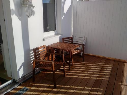 two chairs and a wooden table on a porch at Fürstenhof - Ferienwohnung 106 in Sassnitz