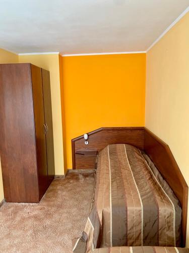 a bed in a room with yellow walls at Hotel Elena in Veliko Tŭrnovo