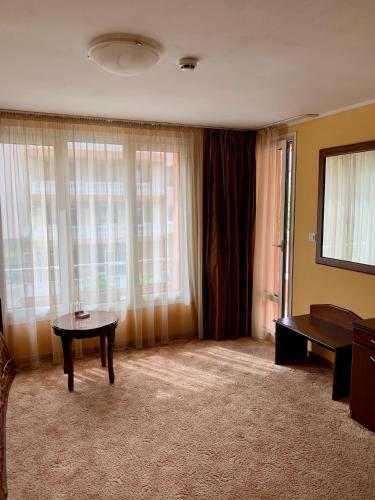 a living room with a table and some windows at Hotel Elena in Veliko Tŭrnovo