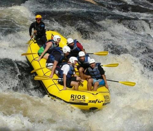 a group of people in a raft on a river at Pousada Ipê da Serra in Socorro