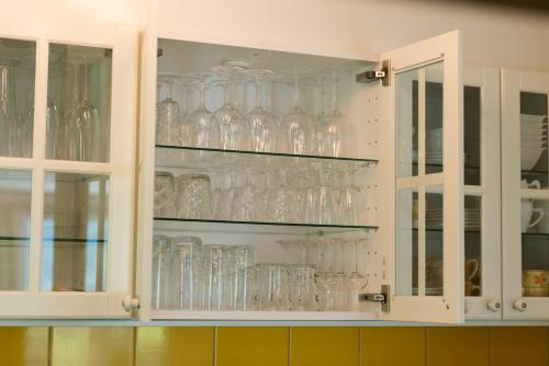 a kitchen cabinet filled with glasses on shelves at Chalet Ravenstein in Fiesch