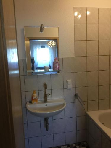 a bathroom with a sink and a mirror at Sunshine Cottage in Waldsolms