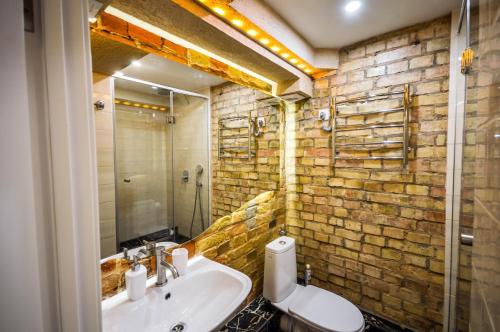 a bathroom with a sink and a toilet and a mirror at Kyiv Art Apartments near Golden Gate in Kyiv