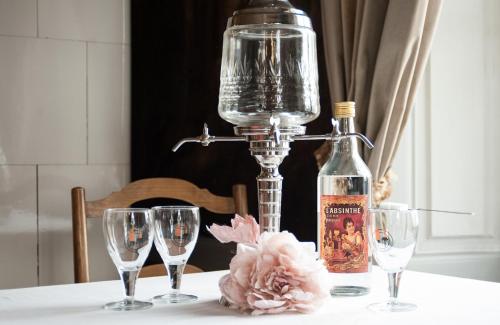 a table with glasses and a bottle of wine at Maison DuBois in Le Locle