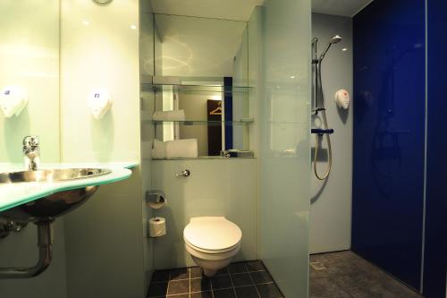 a bathroom with a shower and a toilet and a sink at Park Inn by Radisson Birmingham Walsall in Walsall