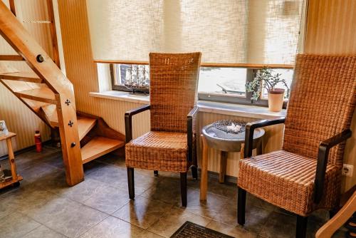 um quarto com duas cadeiras, uma mesa e uma janela em Guest House Šampētera māja em Riga