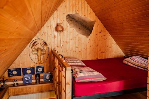 Habitación con cama en una cabaña de madera en Guest House Šampētera māja, en Riga