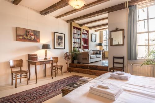 阿姆斯特丹的住宿－優雅17號C運河屋公寓，一间带桌椅的客厅和一间客厅。