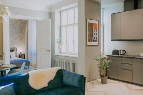 Il comprend un salon avec un canapé bleu et une cuisine. dans l'établissement EDEN APARTMENT, à Riga