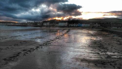 a view of a beach with footprints in the sand at Beside the Bay in Millport