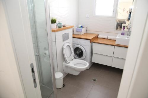 a bathroom with a toilet and a washing machine at Villa Sea House in Eilat