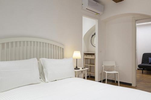 - une chambre blanche avec un lit blanc et une chaise dans l'établissement Modern Holiday Home in Camogli by Wonderful Italy, à Camogli