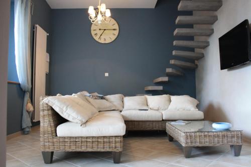 a living room with a couch and a clock on the wall at La Gourgasse Vieille in Béziers