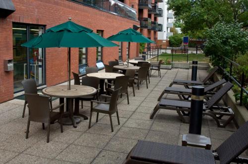 an outdoor patio with tables and chairs and umbrellas at Cartier Place Suite Hotel in Ottawa