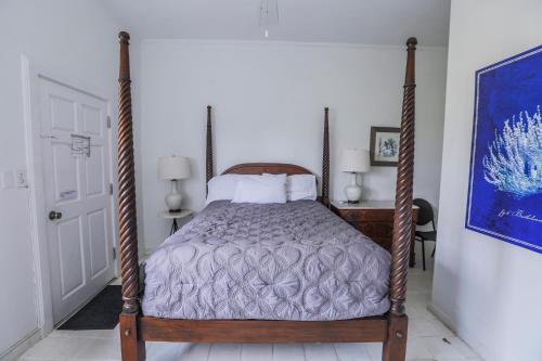 a bedroom with a bed with a wooden frame at Sugar Apple Bed and Breakfast in Christiansted