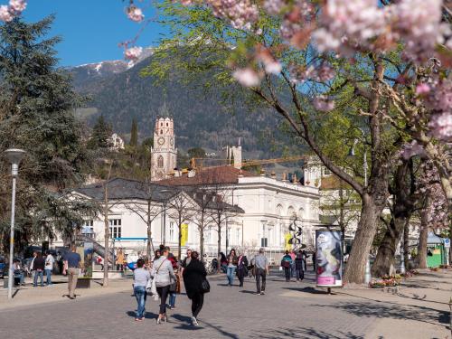 a group of people walking down a street in front of a building at Apartments Sabine G in Merano