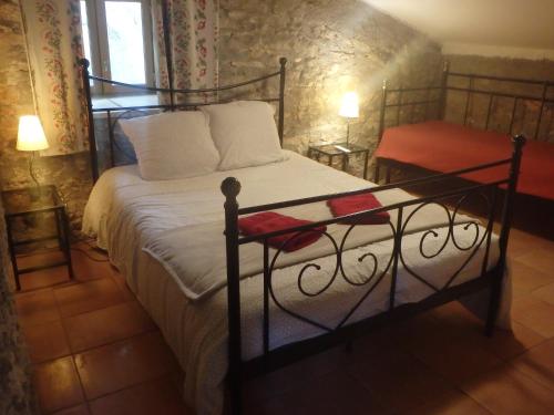 a bedroom with a large bed with a metal frame at Chambres d´Hôtes Prieuré d'Orniols in Goudargues