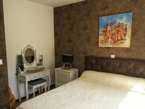 ein Schlafzimmer mit einem Bett und einem Wandgemälde in der Unterkunft La Petite Source in Montendre
