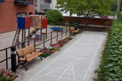 a park with two benches and a playground at Cartier Place Suite Hotel in Ottawa