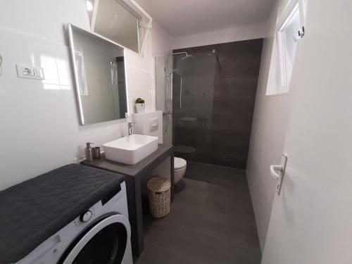 a bathroom with a sink and a washing machine at Apartment Boni in Šibenik