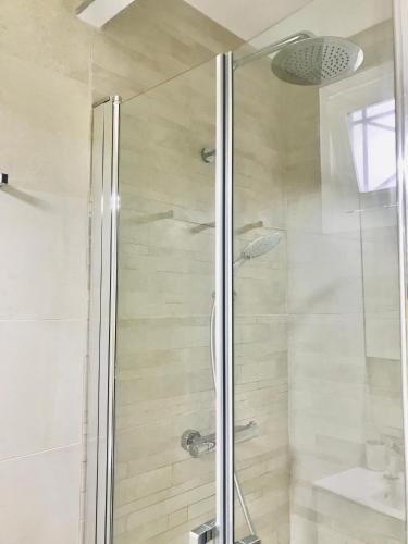une salle de bain avec une douche avec une porte vitrée dans l'établissement Appt 5pers Centre St Jean de Luz - Calme - Grande Plage à 2mn - Balcon, à Saint-Jean-de-Luz