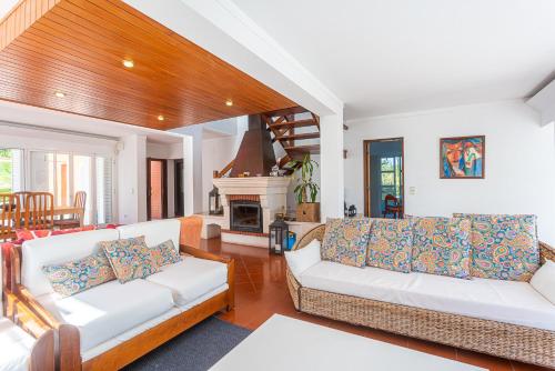 a living room with two white couches and a fireplace at Villa Flora in Sesimbra
