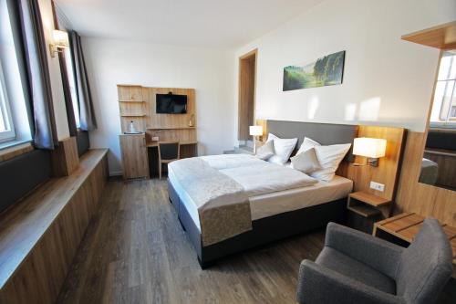 ein Hotelzimmer mit einem Bett und einem Stuhl in der Unterkunft Hotel Adler in Bad Friedrichshall